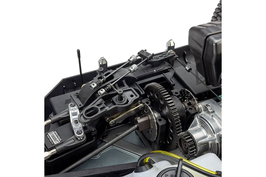 Close-up studio view of the internal chassis, steering linkage, gears, and servo of a 1/5 scale petrol RC truck.