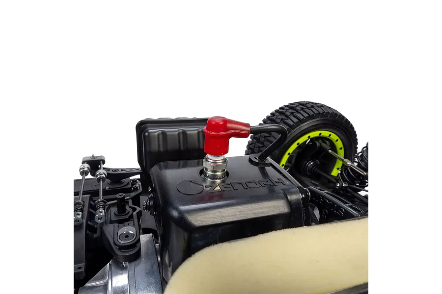 Close-up view of the petrol engine and spark plug with red boot inside the Losi 35.2cc 5IVE-TG 3.0 RC short course truck.