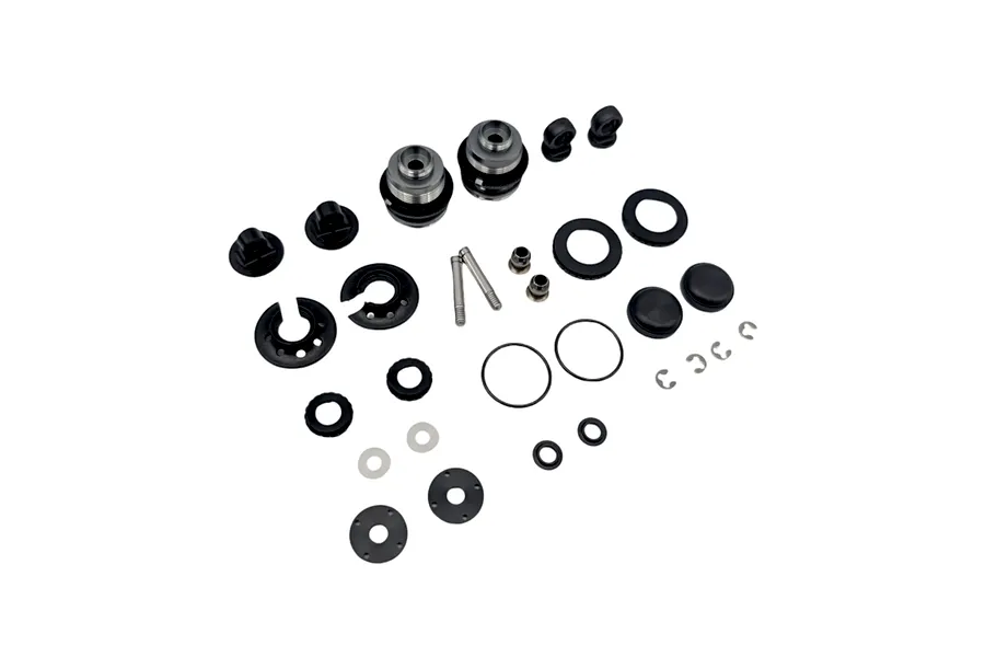 Disassembled parts for an RC Maker XS linear shock set including caps, washers, o-rings, and screws laid out on a white background.