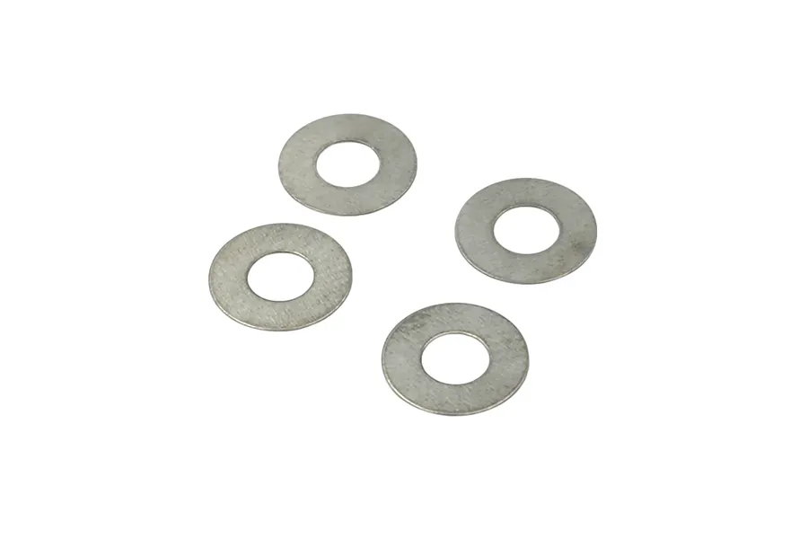 Four small silver metal shims or flat washers laid out on a plain white background.