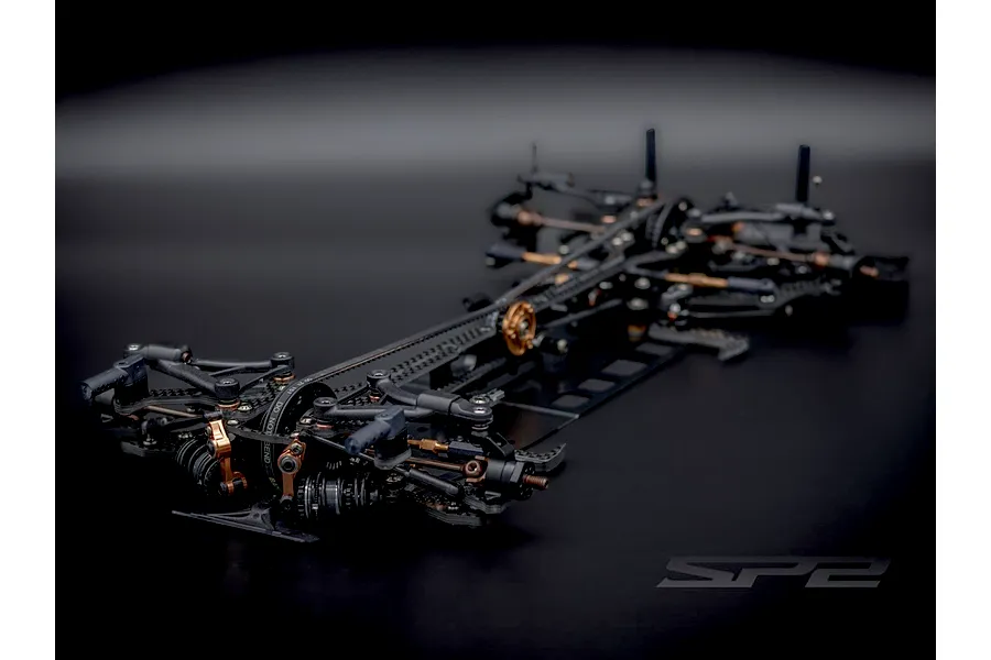 Studio product view of the RC Maker SP2 EP RC touring car chassis featuring carbon fibre and metal components.