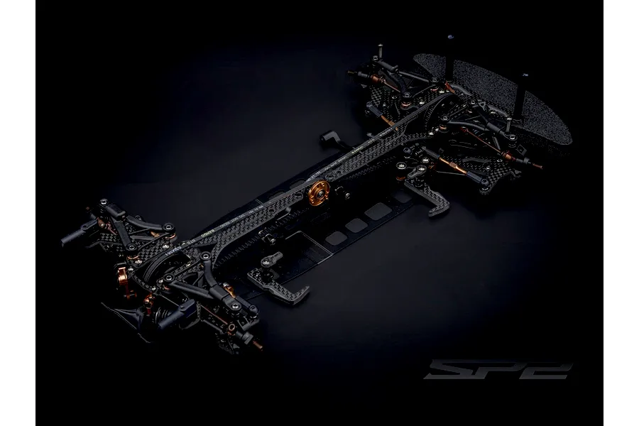 Top down studio shot of the RC Maker SP2 EP RC Touring Car chassis kit featuring carbon fiber and metal components.