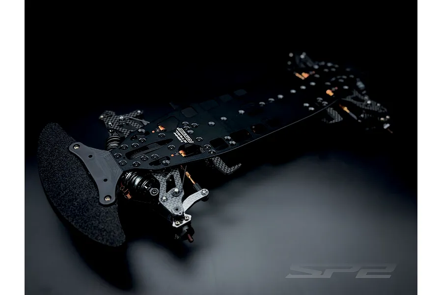 RC Maker SP2 EP RC Touring Car chassis kit viewed from a high angle against a dark studio background.