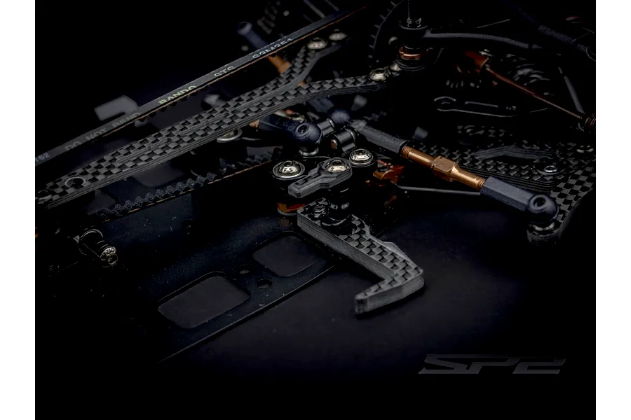 Close-up view of the aluminum chassis and carbon fiber components of the RC Maker SP2 1/10 scale touring car.