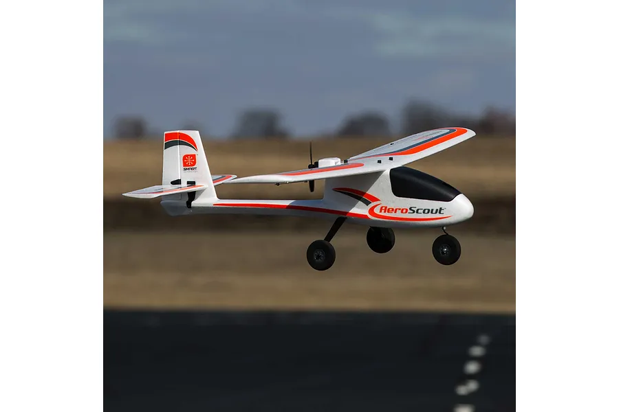 HobbyZone AeroScout S 2 RC trainer airplane flying outdoors against an out of focus background.