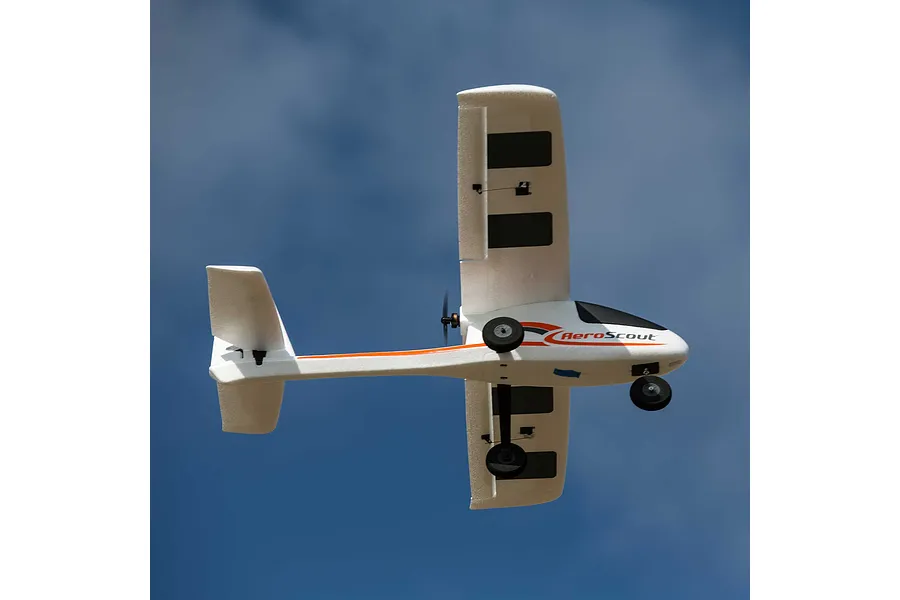 HobbyZone AeroScout RC airplane flying overhead against a clear blue sky background.
