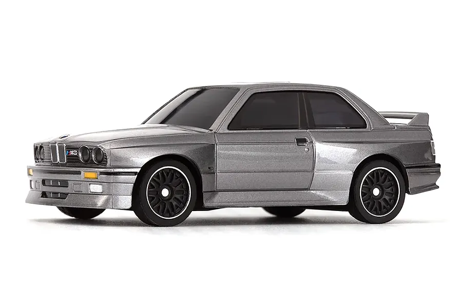 Studio product photo of a grey 1989 BMW M3 RC drift car viewed from a front three-quarter angle against a plain white background.
