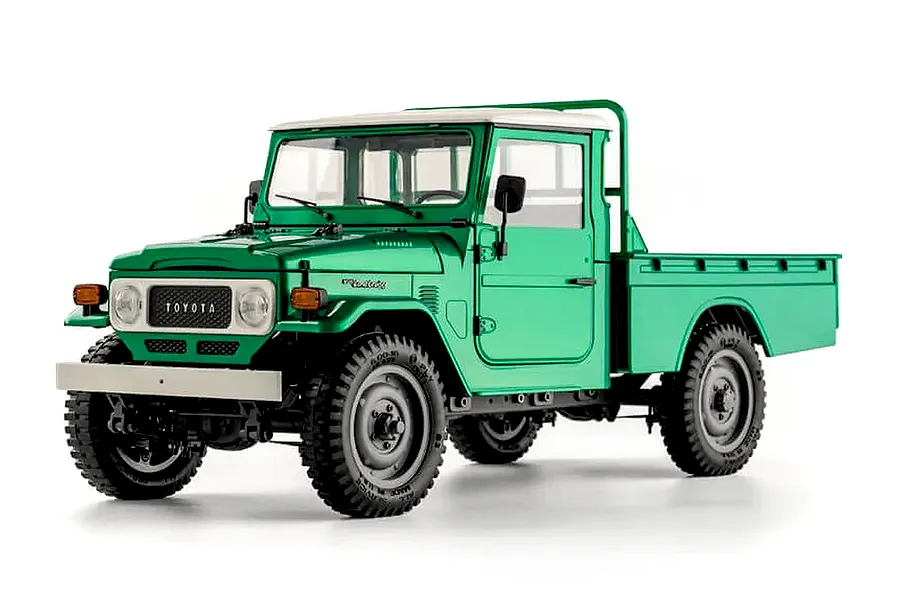 Studio shot of the FMS Toyota FJ45 RC rock crawler in green with a white roof and flatbed.