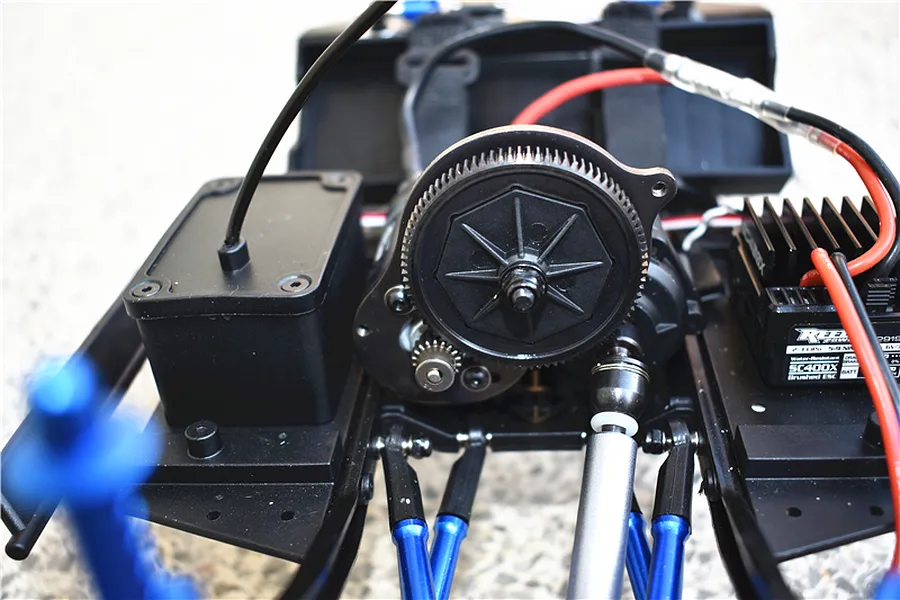 Close-up view of an RC car chassis showcasing the installed spur gear, motor, and drivetrain components.