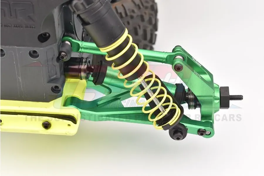Close-up view of an RC car suspension featuring green aluminium suspension arms, tie rods, and a driveshaft installed on a chassis.