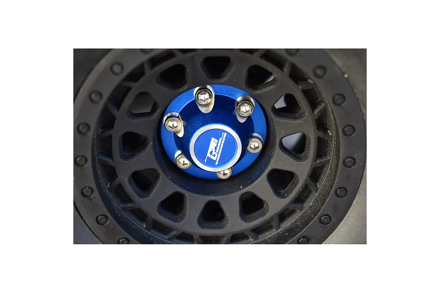 Close-up of a blue aluminium wheel nut installed on a black RC car wheel with silver screws.