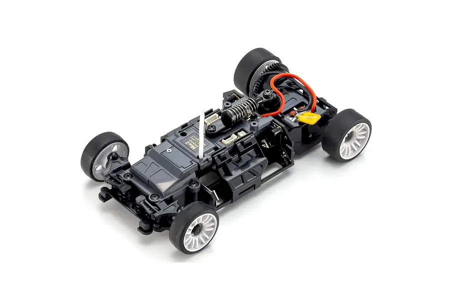 Overhead studio view of an assembled black plastic RC car chassis with wheels, suspension, and wiring on a white background.