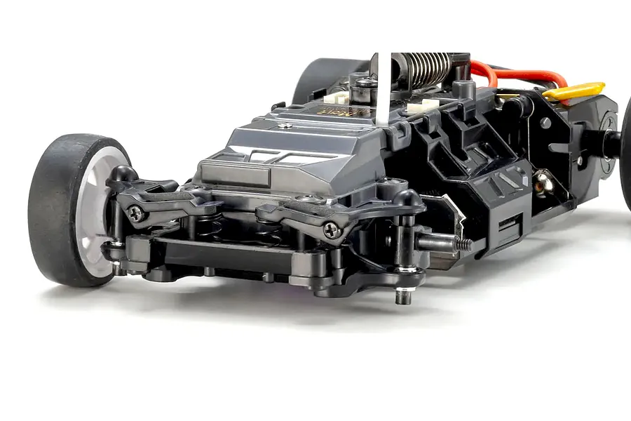 Close-up studio shot of the RC car chassis showing front suspension, wheels, and internal components against a white background.