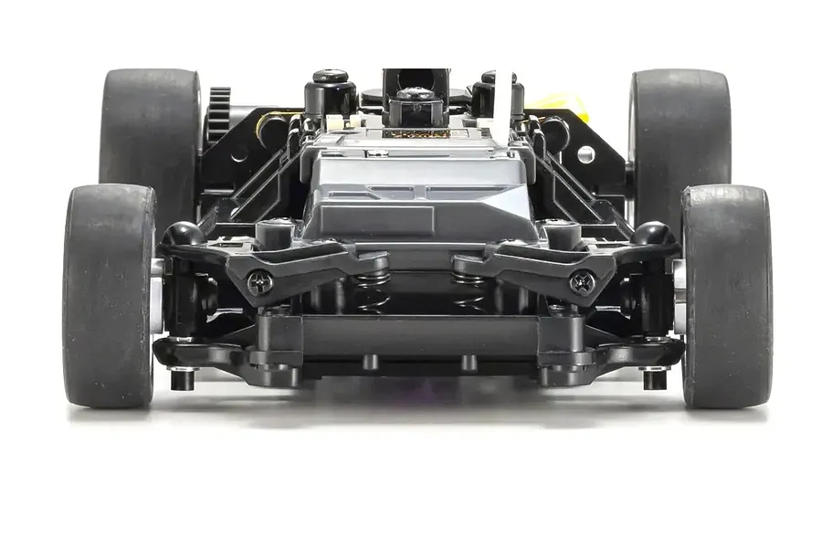 Front view of an RC car chassis showing the front suspension, steering links, and rubber tires against a white background.