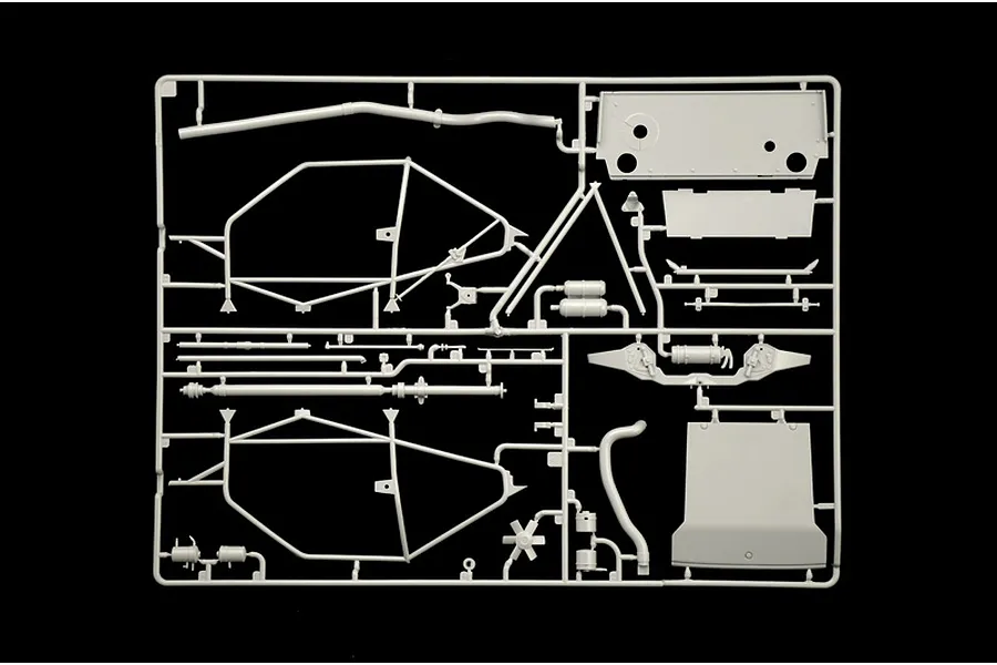 Grey plastic model kit sprue containing interior roll cage parts and chassis components against a black background.