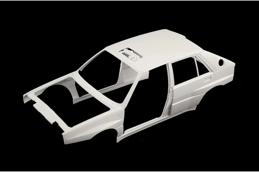 Unpainted white plastic model car body shell for the Italeri Lancia Delta Integrale against a black background.