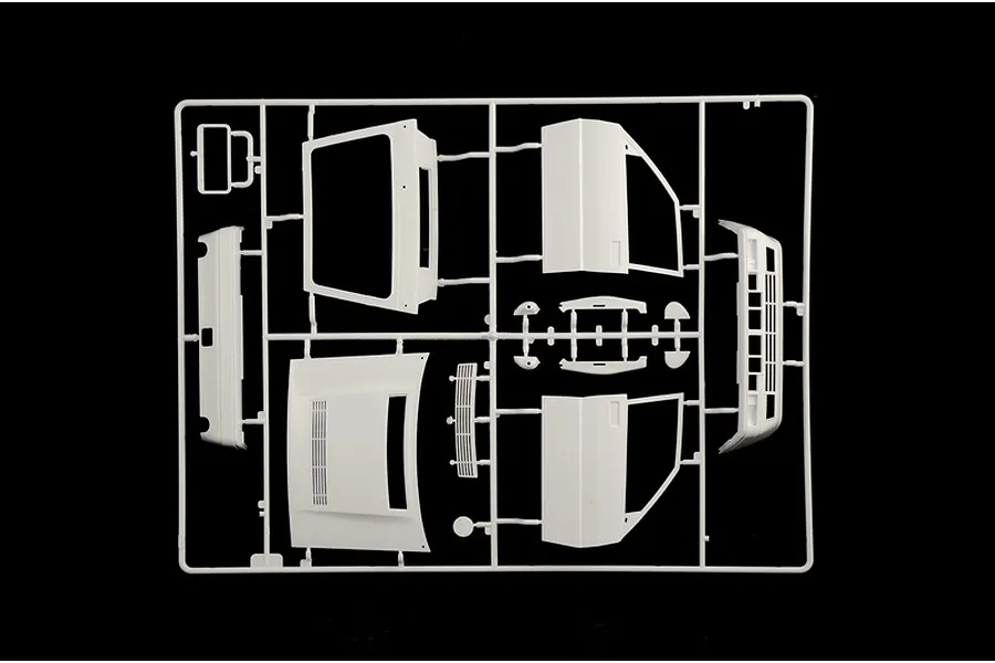 A white plastic model kit sprue containing car parts like body panels and doors against a black background.