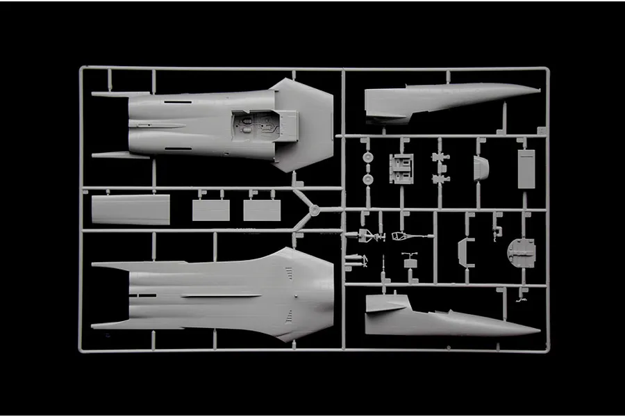 A grey plastic model kit sprue containing aircraft fuselage halves and various smaller detail parts against a black background.