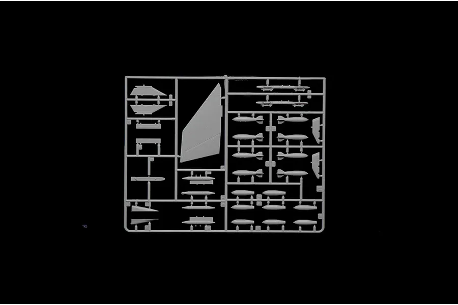 Grey plastic model kit sprue containing aircraft parts such as wings, weapons, and ordnance on a black background.
