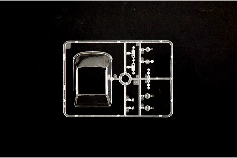 Clear plastic model kit sprue containing windows and transparent parts for a 1/24 scale car model against a black background.