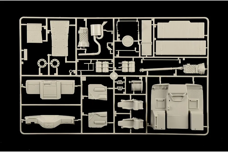 Molded grey plastic model sprue featuring truck interior and chassis parts against a black background.