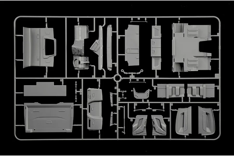 Grey plastic model kit sprue containing various truck interior and body parts on a black background.