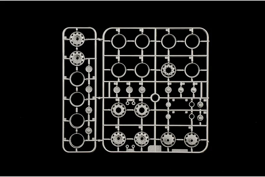 Grey plastic model sprue featuring wheel rims and hubs on a plain black background.