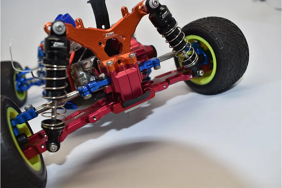 Close-up of the rear chassis and suspension components installed on an RC buggys chassis against a white background.