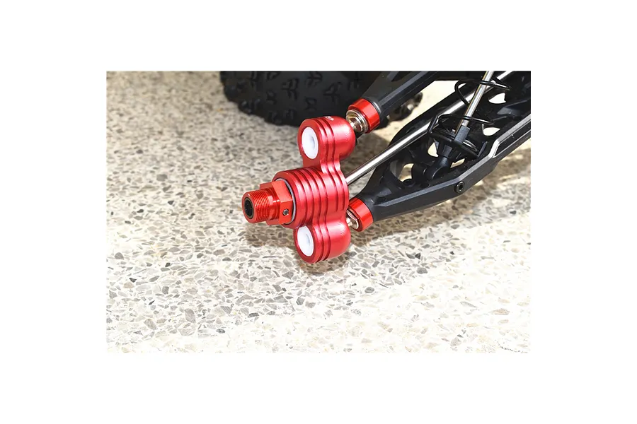 Close-up of an orange anodized aluminium steering hub installed on an RC car suspension assembly.