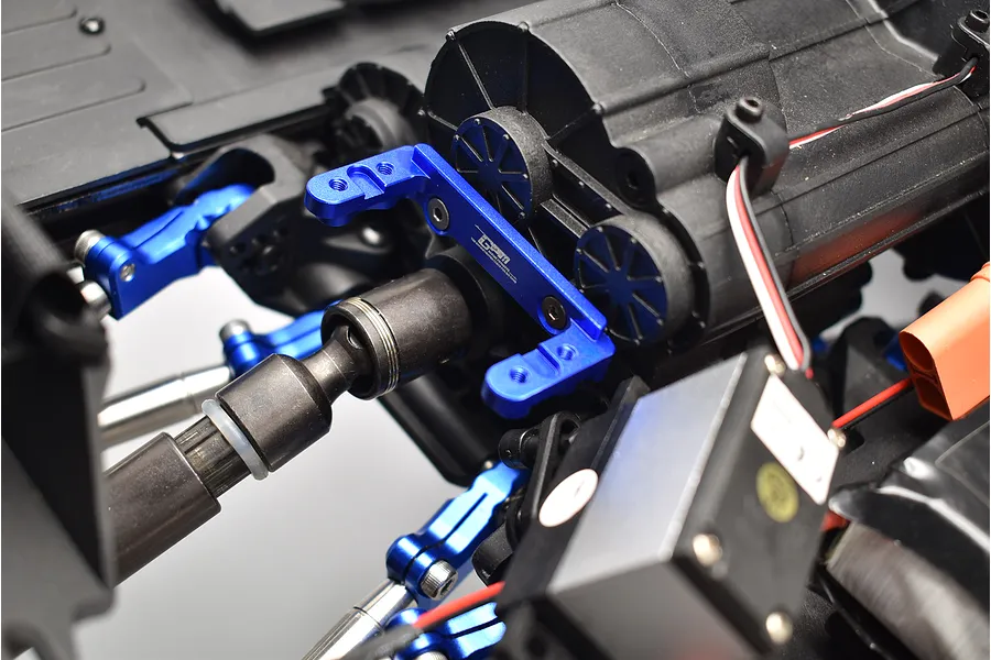 Close-up of a blue anodised aluminium GPM servo mount installed on an RC car transmission housing.