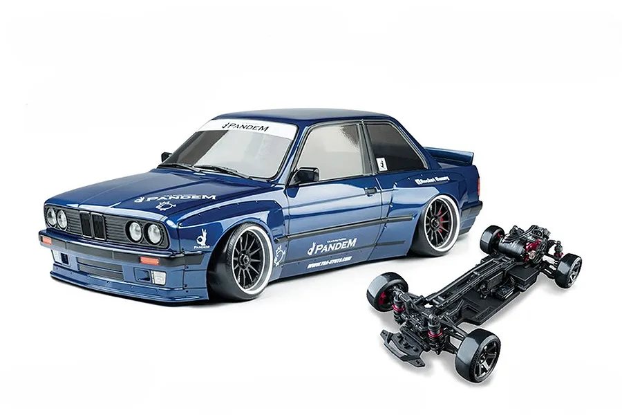 Dark blue E30RC drift car body with Pandem decals alongside its black RC chassis on a white background