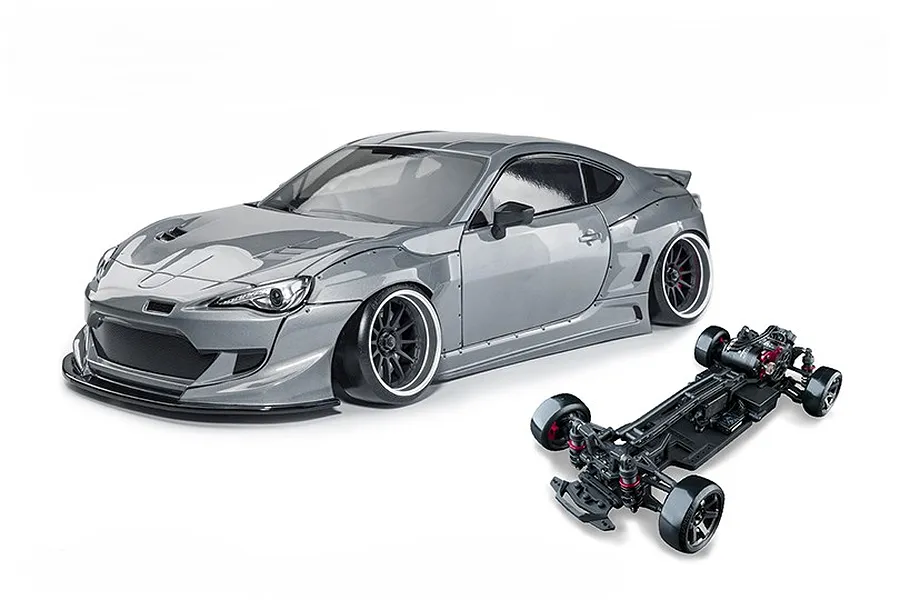 Studio shot of a metal grey 86RB RC drift car body and its matching black chassis on a white background.