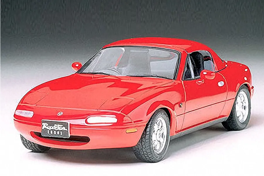 A completed Tamiya 1/24 scale model of a red Mazda Eunos Roadster with a hardtop, viewed from the front three-quarter angle.