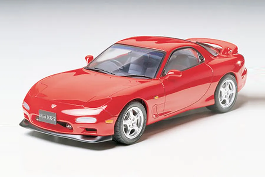 A fully assembled and painted 1/24 scale Tamiya Mazda Efini RX-7 plastic model car in red, shown from a high-angle front three-quarter view.