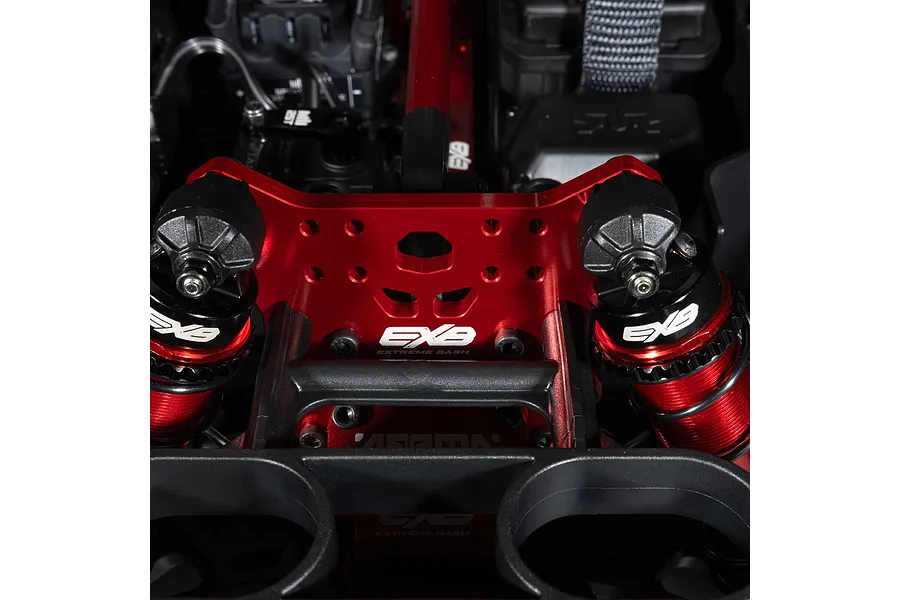 Close-up of the red anodized aluminum shock tower and EXB branded suspension components on the ARRMA Mojave 6S RC car.