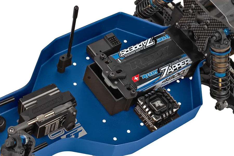 Close-up of the blue anodized aluminum chassis on a Team Associated RC car, showing installed electronics, battery, and servo.