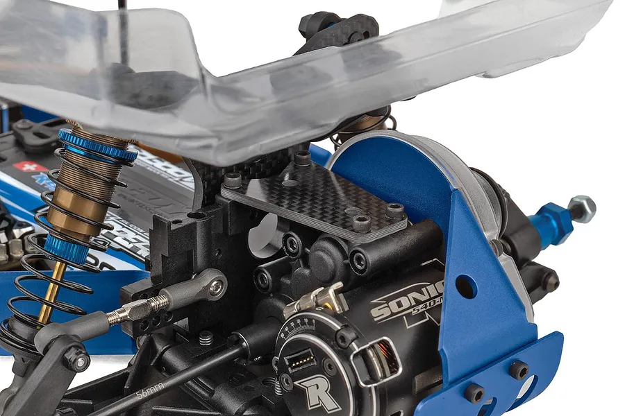 Close-up studio shot of the rear chassis, shock absorbers, carbon fiber shock tower, and blue motor mount of the Team Associated RC10 bugg