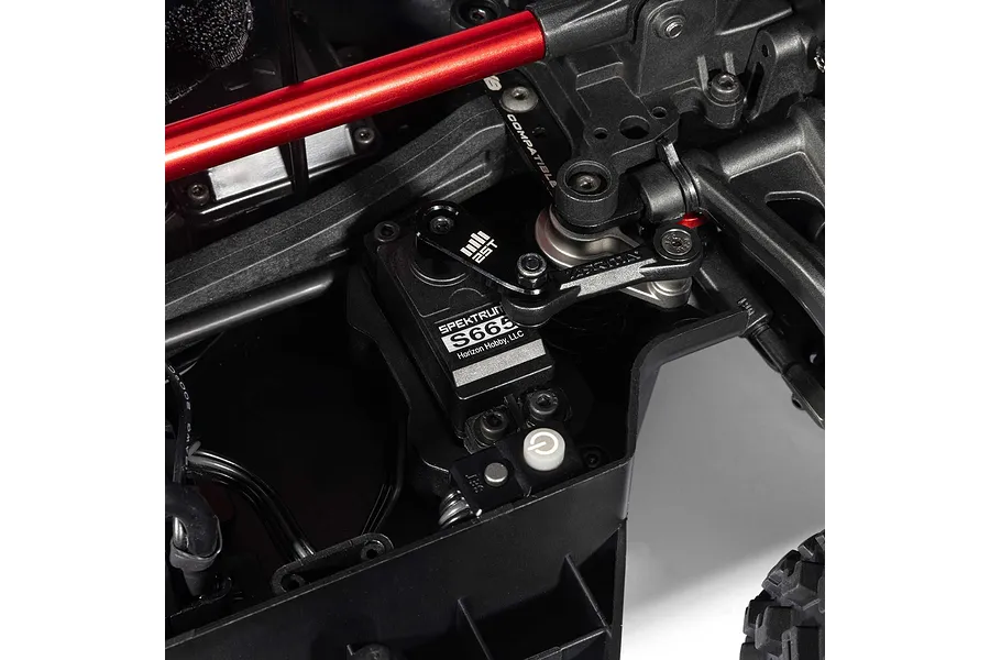 Close-up studio view of the steering servo, linkage, and chassis components inside the ARRMA MOJAVE 6S RC truck.