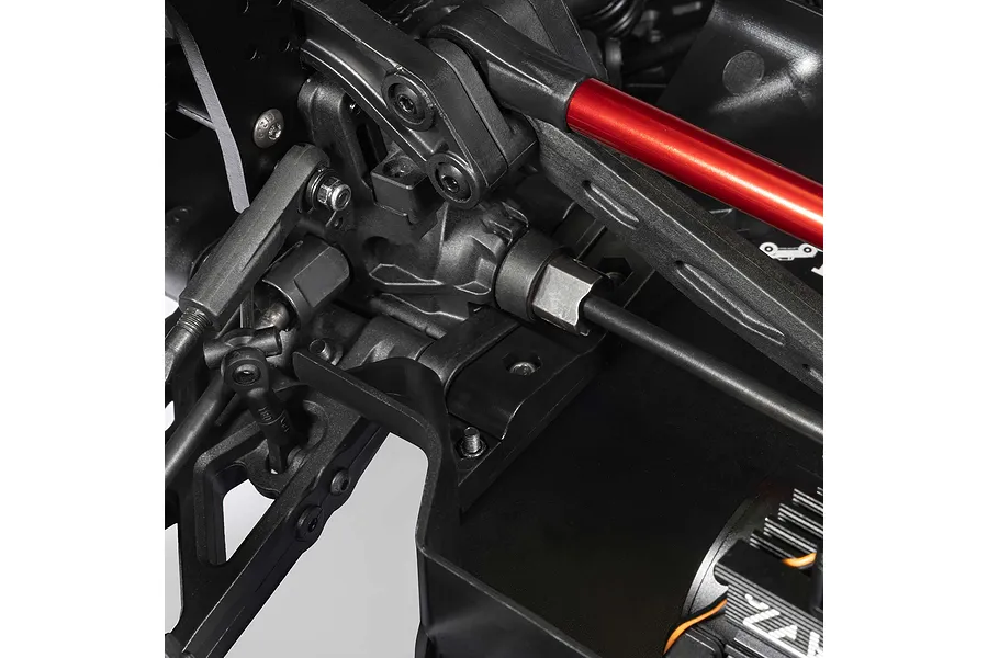 Close up view of the internal RC chassis components, suspension arms, and drive shaft on an ARRMA MOJAVE 6S.