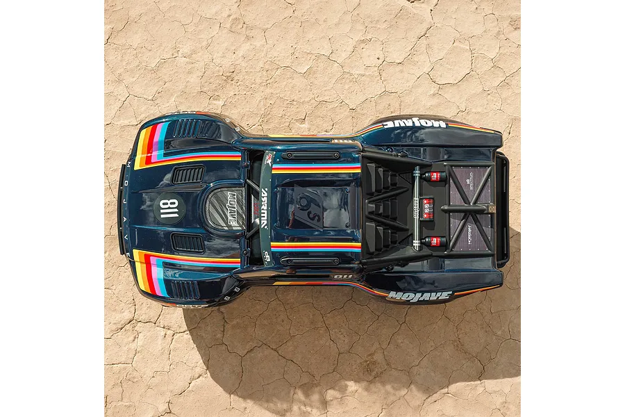 Top-down view of the blue ARRMA Mojave 6S RC short course truck parked on dry cracked earth ground.