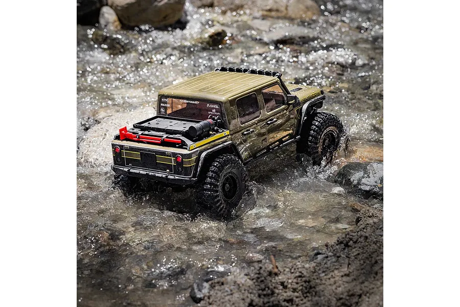 Axial SCX10 III RC rock crawler driving through shallow flowing water over rocky terrain outdoors.