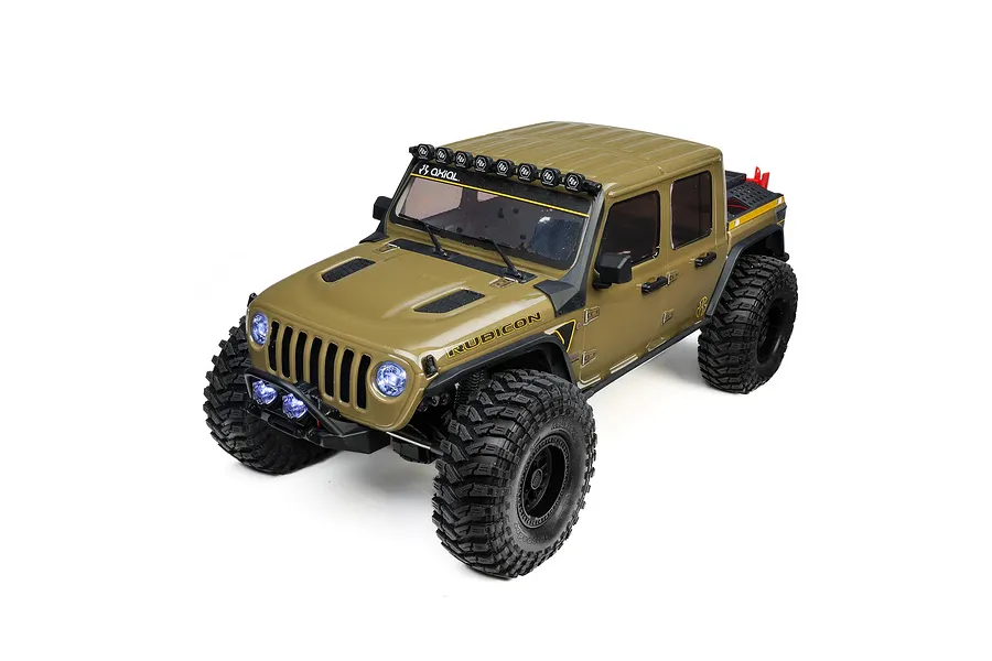 Studio product shot of an Axial SCX10 III green Jeep RC rock crawler with lit headlights and roof lights on a white background.