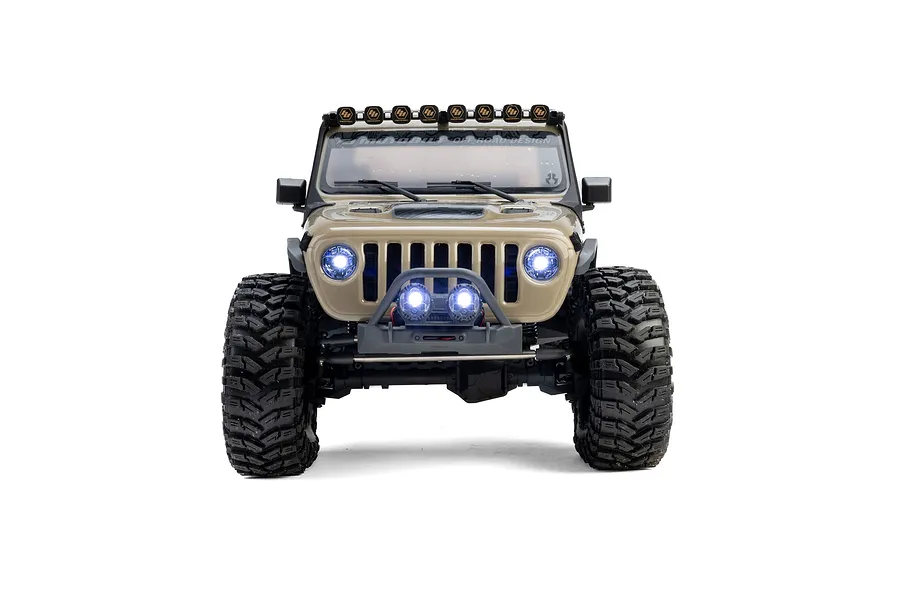 Front view of the Axial SCX10 III Motobilt Valyrian RC rock crawler in tan, showcasing illuminated headlights and bumper lights.