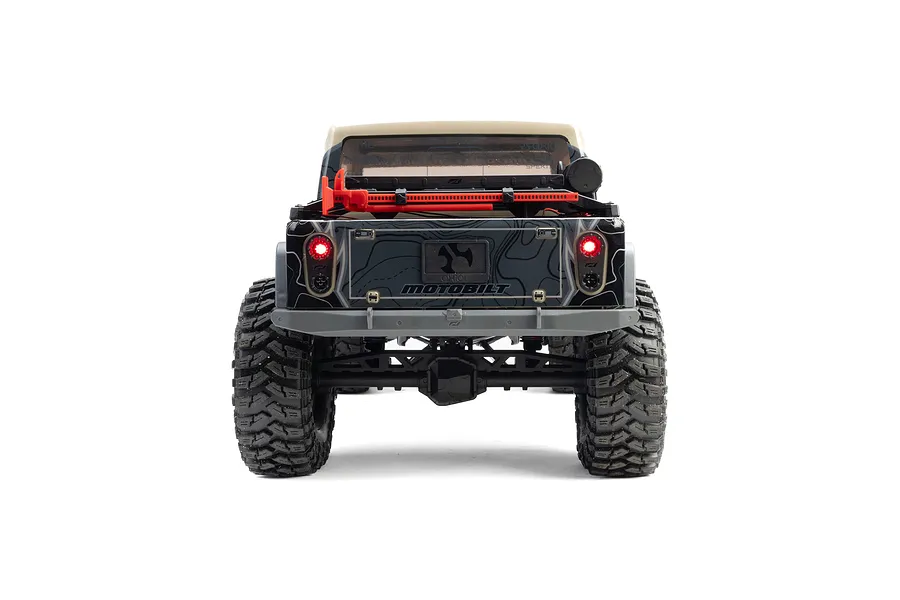 Rear view of the Axial SCX10 III Motobilt Valyrian Jeep JT Gladiator RC crawler in tan, showing glowing taillights and truck bed details.
