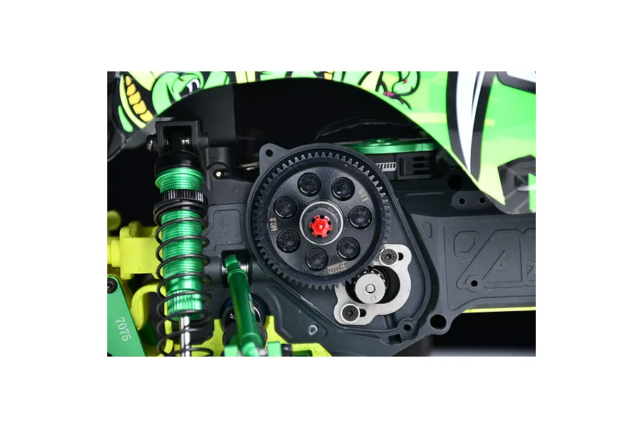 Installed GPM silver motor mount plate and spur gear inside a green and black RC monster truck chassis.