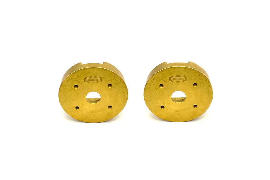 Two brass weighted portal covers with laser-etched Reefs logo on a plain white background.
