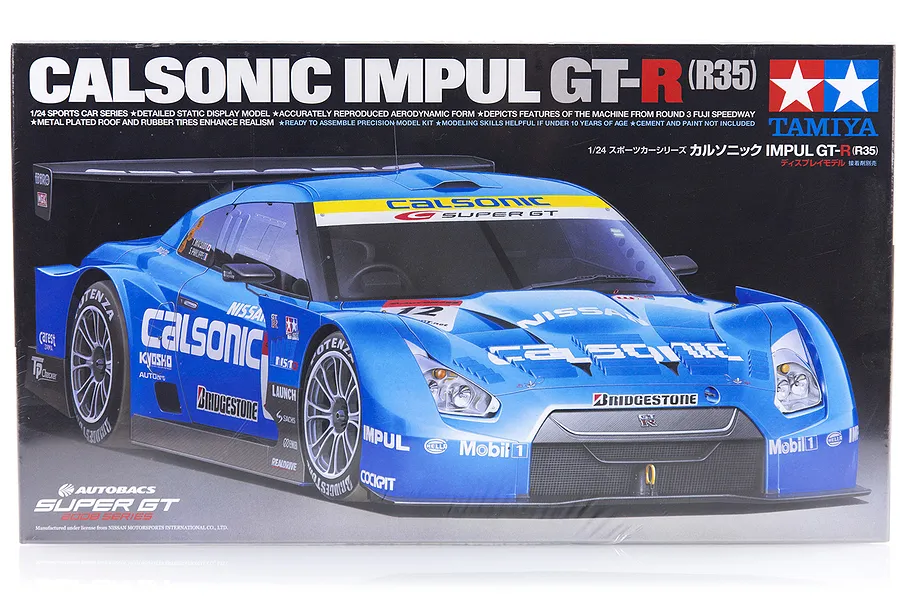 Tamiya 1/24 scale Nissan Calsonic Impul R35 GT-R plastic model kit box art showing the blue race car.