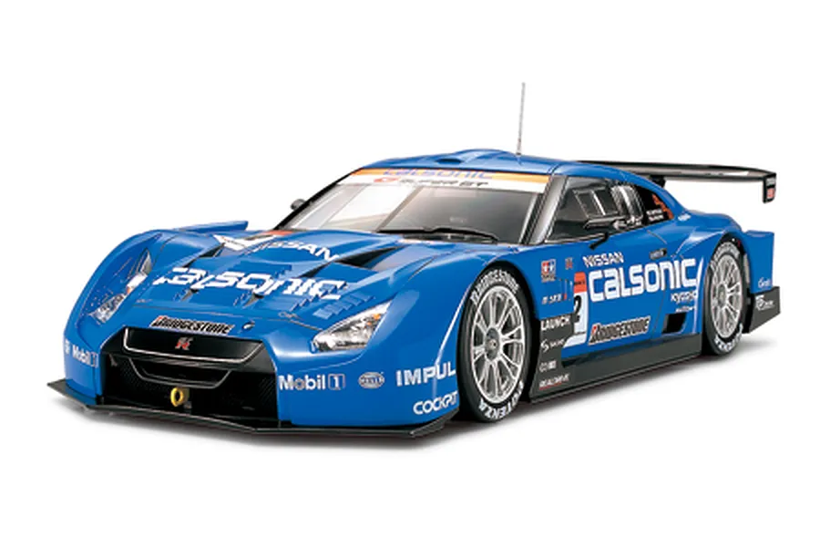 A studio shot of a finished 1/24 scale Tamiya Nissan Calsonic Impul R35 GT-R model car, featuring blue livery and racing decals.