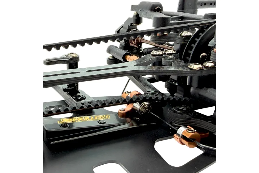 Close-up of RC Maker rear belt tensioner installed on an RC car chassis, showing carbon fibre and aluminium components against a white background.