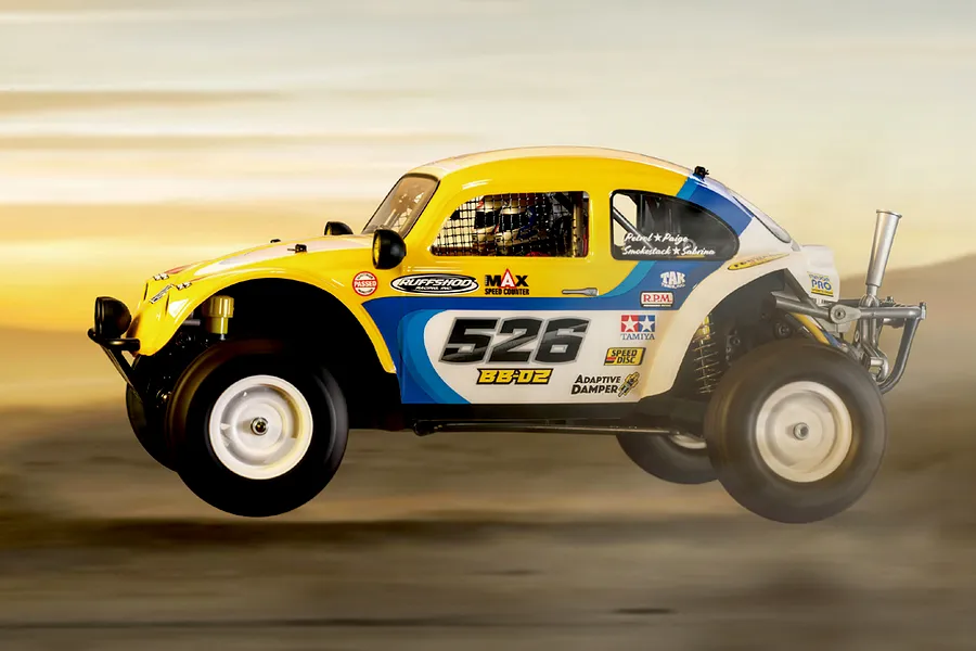 Side profile of a yellow and white Tamiya BB-02 Volkswagen Dune Beetle RC buggy mid-air in an outdoor desert setting.